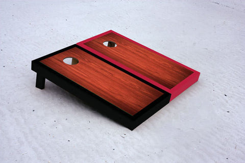 Custom cornhole boards with black and red borders with rosewood stained center
